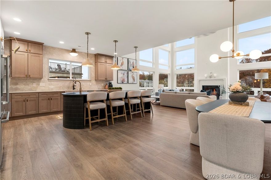 Experience luxury in this stunning 5,500 sq ft home that blends classic & modern design for a refined European feel. Nightly rentals are allowed, making it an exceptional investment opportunity. This beautifully crafted residence offers 5 bedrooms, 5.5 baths, & 4 ensuite rooms, including two gorgeous primary suites. Every inch has been thoughtfully designed, stylish, & truly move-in ready. The gourmet kitchen impresses with a butler’s pantry featuring a full-size refrigerator, microwave/convection oven, & prep sink. An expansive island & custom range hood elevate both elegance & function. Soaring 24' ceilings & a custom fireplace define the grand living room. Perfect for entertaining, the lower level offers a wet bar with microwave/oven combo & refrigerator, plus a spacious laundry room. A 3-car garage with golf cart path provides ample parking & easy lake access. Durable fiber-cement siding & stucco frame the exterior, while a generous back porch showcases breathtaking 18MM views— w/ plenty of room to add a pool and expand your outdoor oasis. Sales comes with a 14x40 Boat Slip @Harbor 19 and See Attached Plans & Permit to Add a 14x40 Dock w/ swim Platform to the home.