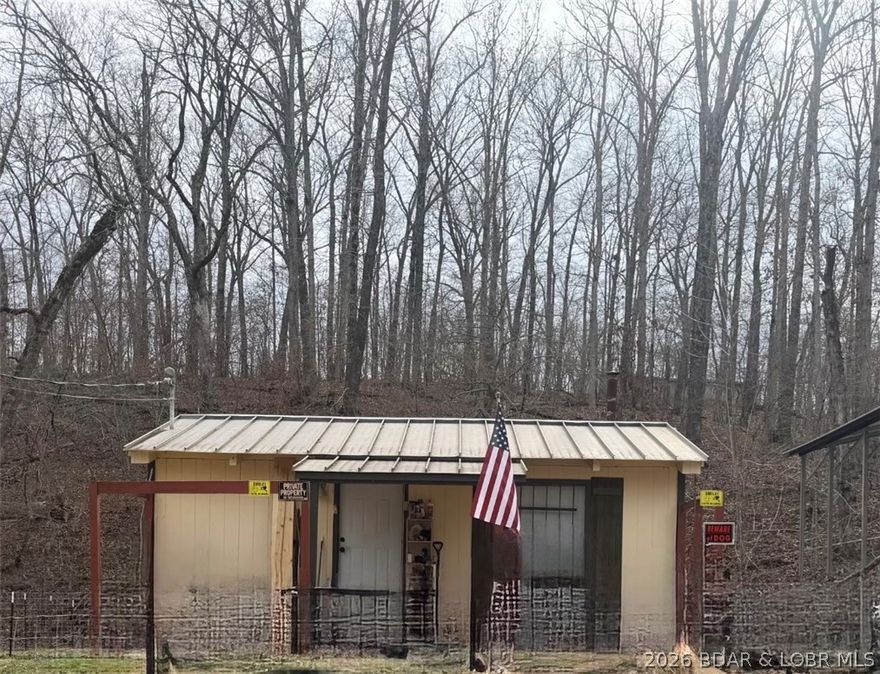 This affordable cabin in the woods is a smart pick for investors, weekenders, or anyone wanting a low-maintenance getaway. Minutes from the lake and the new Ozark International Raceway, it’s ideal for short-term rentals, hunting retreats, or long-term tenants. Recent updates include new appliances, new front door, new faucets, new glass sliding shower door, and fresh interior paint. Cozy woodstove keeps winter heating costs low. The layout offers a kitchen, bathroom, living area, and a raised loft over the washer/dryer hookups—great for sleeping space or storage. Quiet setting with wildlife and room to add value. Water is Ivy Bend Water District; private septic. Parking for 2–3 vehicles and extra space to the left for a garden or the option to enclose the carport for a detached garage. A solid income-producing opportunity at an accessible price.