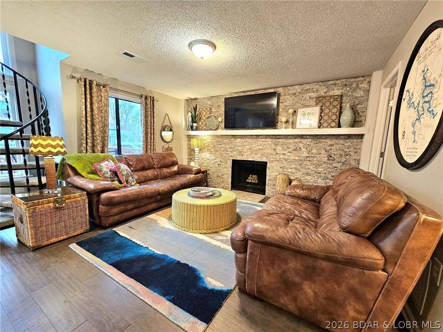 Imagine living the LAKE LIFE in this charming A-Frame home boasting 100 feet of stunning lakefront. The property includes two bedrooms on the main level, and a spacious loft that serves as a third bedroom.  A lower level featuring the kitchen, dining area, fireplace, laundry, and living space. You'll find the expansive deck, ideal for relaxing or entertaining, just off the kitchen/dining area on the lower level. The dock is cove-protected and stays afloat year-round. This home underwent a complete remodel in 2017, and recent upgrades include a new blacktop driveway in 2025, along with a new septic system and roof in 2024. Conveniently situated just five minutes from town, this location is also near various lakefront restaurants and bars, including Shady Gators and many others. This home can be a short term rental opportunity and there is some rental history. Don't waste anytime, call today and schedule your private tour.