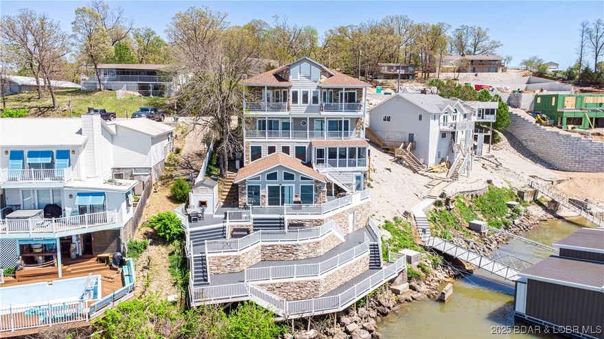 Indulge in the ultimate lakefront lifestyle at this exquisite residence nestled on the coveted Grand Glaize Arm of the Lake of the Ozarks. Boasting six spacious bedrooms and five luxurious bathrooms, this home offers an unparalleled retreat for family and friends. Imagine evenings spent in the game room, crafting cocktails at the bar, or soaking in breathtaking panoramic lake views from multiple expansive decks. The entire main floor is dedicated to a stunning primary suite, offering a sanctuary of privacy and elegance. With a new roof ensuring peace of mind, this property presents an exceptional opportunity for full-time living or a lucrative investment, with a proven track record of increasing rental income. A two-car attached garage and additional parking add convenience. Situated in a prime Osage Beach location, you'll enjoy effortless access to local amenities and be moments away from the future Oasis at Lakeport amusement park, the popular Dog Days Restaurant, the legendary Party Cove, and the thrilling Shootout race course – all easily reachable by land or lake. Home to be sold "As Is". Currently under contract with a 72hr kick-out contingency.