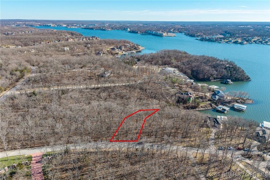 Enjoy the charm of ever-changing lake scenery with this Seasonal View lot at The Villages at Shawnee Bend. Partial lake views emerge throughout the year, offering a unique connection to the surrounding landscape while maintaining privacy and natural beauty. The community sets itself apart with a grand waterfall entrance and an impressive lineup of amenities, including a clubhouse, resort-style pool, championship tennis courts, and pickleball facilities. Parks, and playgrounds enhance the lake lifestyle, while paved streets and underground utilities provide modern convenience. This lot is ideal for a full-time residence or a relaxing weekend escape.