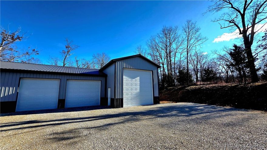 Sellers say bring your reasonable offers and they will take a look! The perfect blend of privacy and convenience in a fabulous location! This versatile property sits on 5± acres just outside city limits and offers a 30x30 shop with 12x30 living quarters with a covered patio, 220 hookups for electric stove in kitchen, plus a 20x50 RV garage with two 50-amp RV hookups (one inside and one outside) RV dump on back side of building. Enjoy city water, private septic, and a massive, graveled parking area—ideal for RVs, equipment, or guests. 12,000 BTU Ductless mini split heating/cooling in living quarters, three 10,000 BTU electric heaters, 2 in RV side and 1 in shop side, 200 Amp service. Wooded surroundings create a private, peaceful setting, while being just minutes from town and the Lake of the Ozarks. With less than 100 feet of gravel to the driveway, access is easy year-round. Store your RV, your boat, equipment, run a business, expand the living quarters, the possibilities are endless. Whatever your LIFESTYLE may be, this one can be made to fit. You must see to appreciate it!