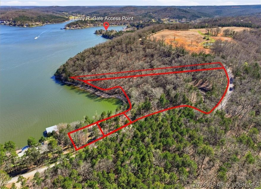 An exceptional opportunity to own 4.4 acres of serene waterfront land on the Niangua Arm of Lake of the Ozarks, showcasing expansive views and direct lake frontage in a deep cove location. This private setting features a natural spring and striking rock formations, and borders protected conservation land, guarding against future overdevelopment. Ideally located near the Larry R Gale Access Point, Old Kinderhook and Old 54, the property offers a rare balance of seclusion and accessibility to modern conveniences. With a partially paved road and some cleared trees, it is perfectly poised for your vision—whether a luxury private retreat, an intimate wooded community, or an event destination. Per the appraisal, 3.3 acres of the land is zoned R-1 (Low Density Residential) and 1.1 acres zoned P-2 (Commercial Parks) with the potential to re-zone. Don’t miss this rare opportunity to own a piece of lakefront with ideal development potential. Imagine the possibilities! Dream. Design. Build.