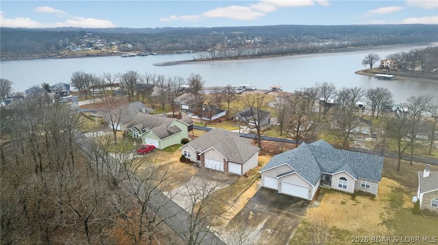 Enjoy beautiful lake views from this well-maintained 4 bed, 3 bath home located in one of the area’s premier neighborhoods at Lake of the Ozarks. With paved roads all the way to the door and central water & sewer, convenience meets comfort in this highly desirable setting. The main level offers 2 bedrooms and 2 full baths, including a spacious primary suite, along with an open floorplan designed to capture lake views from the living, dining, and kitchen areas. Natural light and thoughtful layout make this home ideal for both everyday living and entertaining. The lower level provides additional flexibility with a large family room, two guest bedrooms, a full bath, and ample storage space. A 3-car attached garage includes a deeper bay perfect for boat storage. Built in 2004 by a reputable builder and owned by the original buyer until now, this home has never been on the market. Community amenities include paved roads, central utilities, a boat ramp, and courtesy dock. Excellent location by both land and water with convenient access to town, dining, and entertainment. Whether you’re looking for a full-time residence or a weekend lake retreat, this property checks the boxes.