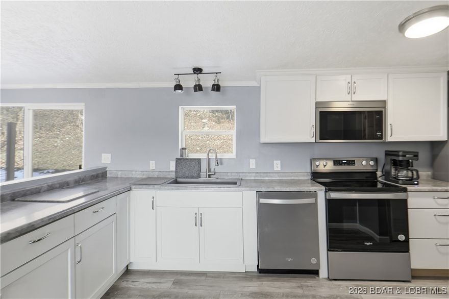 Tidy, clean and updated manufactured home with over 3 acres providing maximum privacy, yet not secluded.  Located in a nice area of well kept properties, this home sits second tier with a seasonal lakeview. Updates include all new flooring, windows, cabinetry, counters and appliances plus lighting. Most windows have been replaced excluding slider and kitchen window. Plenty of room on 3 acres to store your boat and trailer, RV, plus plenty of room to add additional home(s), garages, shops, sheds.  No restrictions, the world is your oyster and no one to tell you otherwise.   A wonderful 12x16 deck for great outside enjoyment  This property is loaded with deer and wild turkey - live where you hunt and hunt where you live.