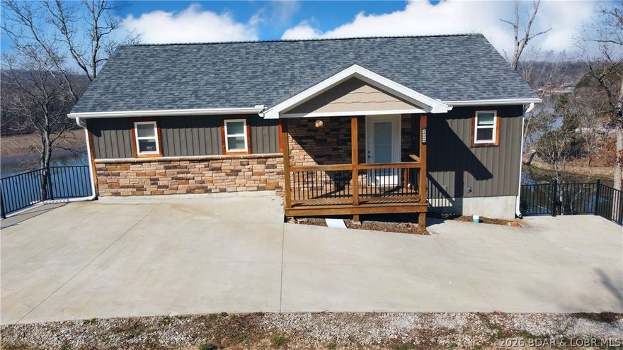 This 3-bedroom, 2.5-bath lakefront home offers over 2,000 square feet of finished living space and is ideally situated on deep water in the desirable Cole Camp Creek arm of the Lake of the Ozarks. The spacious kitchen and living room are filled with natural light and showcase beautiful lake views, creating an inviting main-level living experience with all essential amenities conveniently located on one floor. The lower level features a generous recreation room—perfect for entertaining—along with a secondary kitchen area for added convenience. Walkout access leads to a beautifully graveled and concrete backyard, providing low-maintenance outdoor living and easy access to the two-well dock. Enjoy lake views from multiple outdoor spaces, including an upper-level deck off the living room and primary bedroom, as well as a lower-level deck with walkouts from the rec room and basement bedroom.