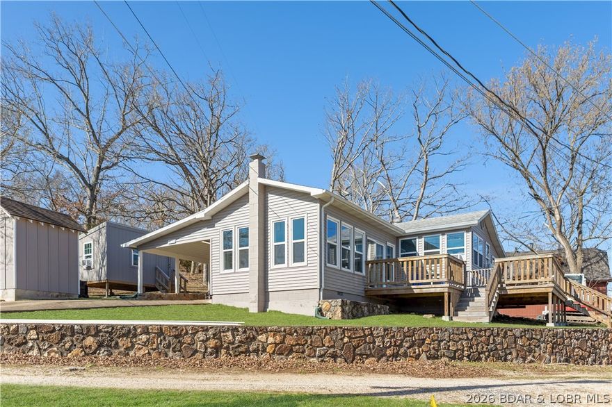Nestled in a serene cove and subdivision, this adorable, well-priced cabin offers a tranquil escape with stunning views of the Lake of the Ozarks. Thoughtfully renovated, the home features modern LVP flooring, new windows, and a recently rebuilt deck. The roof is just 9 years old, and a brand new septic system was just completed! In addition to the main cabin, a charming bunk house adds extra space, though its square footage isn't included in the listing. Boasting a private dock just a short stroll across the street, this retreat is a water lover's dream with tear round deep water. The cabin is being sold turnkey, complete with all furniture, decor, and contents, plus the dock, tri-toon boat, boat lift, jet ski, and drive-on PWC lift. Enjoy proximity to local lakefront hotspots like Lake Burger, Coconuts, and Tap and Grille, making it an ideal package for lake enthusiasts. Whether you're seeking a vacation home or a rental investment, this property offers the perfect combination of comfort, convenience, and value. Don't miss the opportunity to start your lakeside adventure at this delightful cabin.