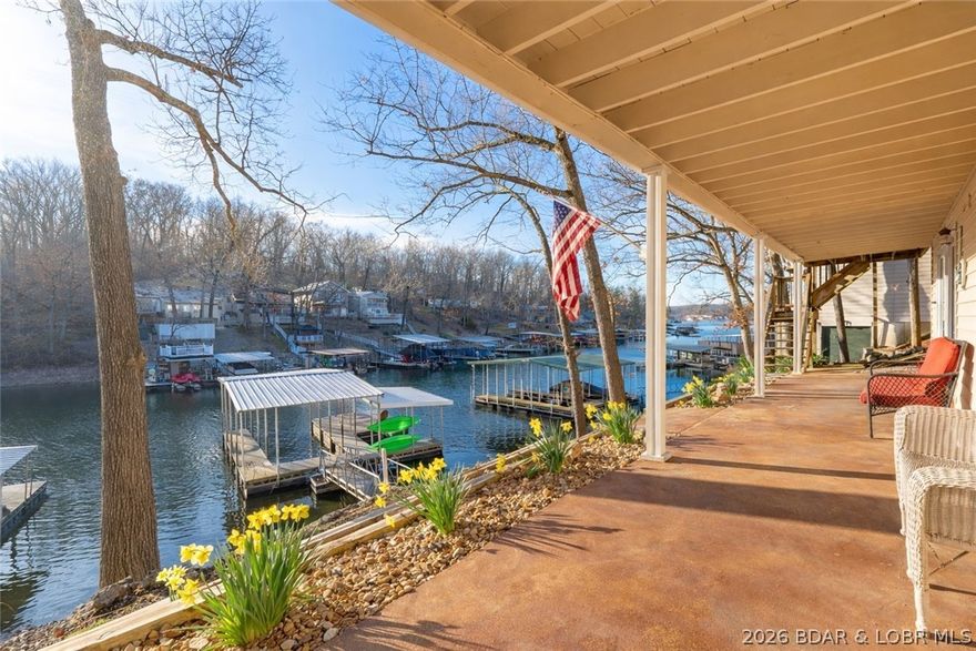 Cozy “Lake Style” vibe is the best way to describe this home with plenty of room to relax and enjoy the water. This 4 bedroom home offers two separate living areas plus a 320 sq. ft. screened-in porch that becomes the perfect hangout spot on spring and summer days. One of the bedrooms features a fun loft space with a handmade ski ladder, adding a unique lake-house touch. The kitchen includes granite countertops, stainless steel appliances, and a brand-new refrigerator, along with the hardwood floors that add character. The entry foyer with built-ins and extra storage helps keep everything organized after a day on the lake. Outside does not disappoint with tons of parking, a storage shed, a large lakeside patio, low-maintenance landscaping and natural stone wall.  Plus, a BRAND NEW roof!  Awesome cove protection with the dock that sits in deep water year-round.  Currently being utilized as a successful vacation rental with 10/10 reviews.  Continue renting for a great ROI or make it your own private family getaway.  The choice is yours….. Check it out TODAY!