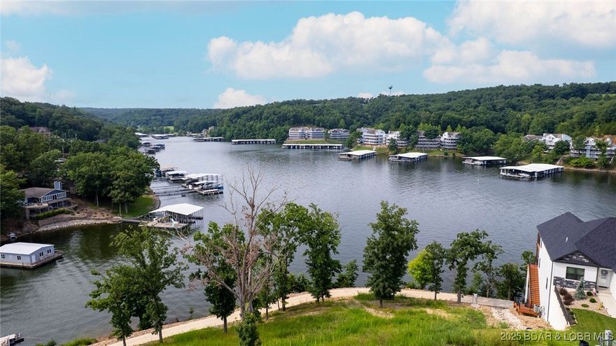 Prime Lake View Villa at The Villas at Tuscany! This stunning 4-bedroom, 3-bath, 2,930 sq. ft. villa offers the best view in the complex overlooking Libby Cove at the 1MM of the Big Niangua. Built in 2022 and meticulously maintained, this home features main-level living, two master suites, granite countertops, stainless steel appliances, hardwood floors, and professionally furnished décor. Enjoy outdoor living on large, covered screened decks on both levels while soaking in the lake views. The spacious primary suite boasts a custom walk-in closet and oversized tiled shower. An oversized 2-car garage provides plenty of room for lake toys. With a gentle driveway and a gated community this helps with ease.  Community amenities include pool, pickleball, fire pit & pavilion, plus golf cart access with no steps to the dock. A 14x40 slip (A-8) with Wet Steps is included in the list price, while a 16x44 slip (A-12) is available for additional purchase and all lifts available as well.  Whether full-time or part-time, this no-maintenance setting offers the perfect balance of luxury, comfort, and lake living—just minutes from the iconic Four Corners! Sellers barely used as a summer getaway.