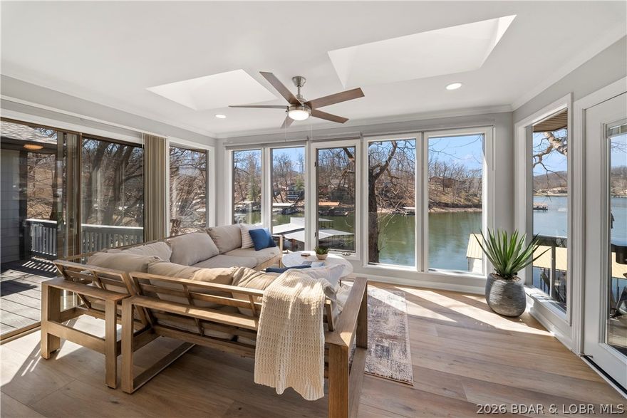 Remarkable opportunity to own a freshly remodeled home ideally situated at 2mm in a great deep water cove. This home offers stunning lake views on both upper & lower levels thanks to 2 breathtaking sunrooms with walls of windows. No interior detail was overlooked & comes tastefully furnished. New 6' plank LVP flooring throughout, beautifully renovated bathrooms showcasing stylish tile & finishes, the updated kitchen is a standout with- heated flooring, custom cabinetry, granite tops & stainless appliances. Spoil your guests with multiple entertaining spaces to hang out in both inside & out- new downstairs bar, open deck & screened-in areas, plus a martini deck to make home even more unique. Spend hours lakeside on the large concrete dock perfect for sunbathing & fishing plus a coveted 16x40 boat slip & PWC Hoist. The fun doesn't stop off the water since large 2-car garage has been converted into a game room complete with tv, pool table, foosball & lots of storage. The driveway & new concrete parking pad allows for multiple guests, perfect if use as nightly rental property. Located in same cove as Buddy's Harbor & just a 2min drive to Bagnell Dam Strip for year round entertainment!