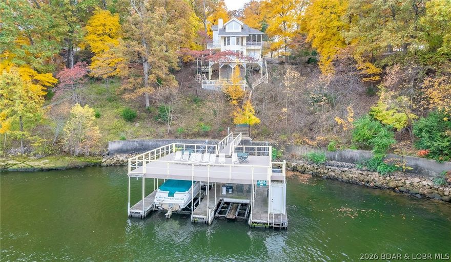 What a magnificent lake home on three lots in Four Seasons! This 3700SF, 4BR/5BA home was built in 1987 with beautiful materials and excellent construction. And wait until you see the two well dock with full upper deck.  Main level living has huge suite plus powder room. Top level consists of an enormous suite, Lower level has full bar, lakeside sitting room, half bath and two more large guest rooms, each with private vanity and share a Jack and Jill bath. Home has been immaculately maintained. Polished marble floors shine and the view of the main channel goes for miles. Custom cabinetry throughout, two car garage and plenty of room for addl parking, screened porch on main level, multiple lakeside decks. The Regal runabout and hoist is included, the double PWC hoist is included. This home is move in ready. Its also perfect for updating and has great original features that will easily translate into today’s décor. Setting allows for great privacy! Be sure to watch the video tour and contact the listing agent for plats and details. Amenities: indoor and outdoor pools, tennis & pickleball, clubhouse, boat launches, campground, storage and much more!