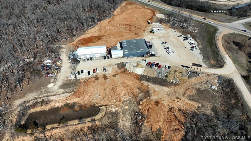 OVER 450 FT OF HWY 54 VISABILITY!!! OVER 400 FT OF HWY 52 & BUS 54 FRONTAGE. Position your business where opportunity meets visibility at 167 Hays Drive, offering nearly 10 acres in a prime location just off Business 54 and Highway 54. This property features a 90x100, red iron, clear span main building heated and cooled, with a 30x40 attached heated and cooled 2 bay shop. The main 90x100 building is complete with four offices, two bathrooms, 3 phase power, and three garage doors for easy access. A 50x100 spray foam insulated shop adds even more versatility with three additional garage doors and the option for three car lifts. The acreage will be leveled, creating room for expansion, storage, or future development, and a billboard provides added exposure. High visibility, easy access, and endless potential make this an exceptional commercial opportunity. Broker Owned