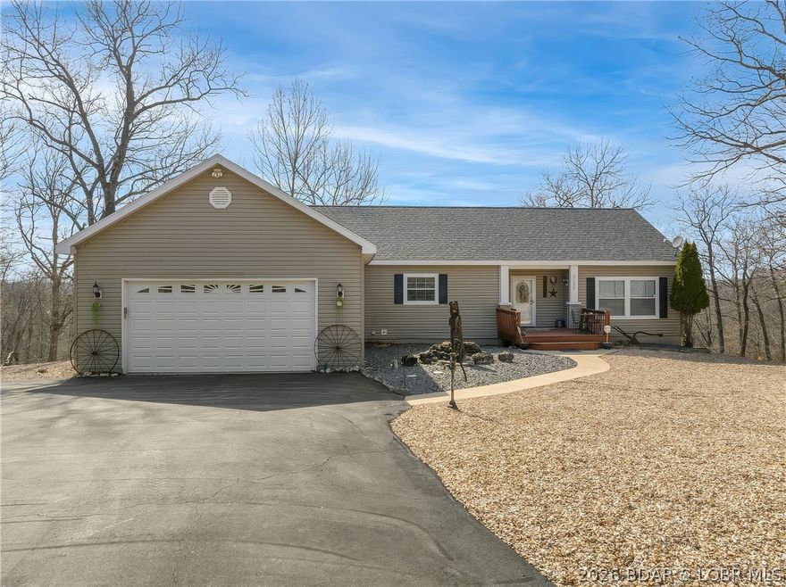 Unique country home with impressive lake views on 1.7 acres & a community dock slip! An inviting front porch welcomes you into an open living, kitchen, & dining area with 9-foot ceilings, wood-burning fireplace & access to a large lakeview deck. The kitchen features an island, breakfast bar, custom oak cabinetry, walk-in pantry & built-in china cabinet. The main-level master suite offers a jetted tub, walk-in shower & spacious walk-in closet. Downstairs opens into an expansive entertainment level designed for "Happy Hour". This cavernous space includes a game area, pool table & TV/lounge area. A custom rustic cedar bar creates a true centerpiece with sink, stove, cabinetry, and refrigerators. The lower level also includes a bedroom, a large bathroom with double sinks & a custom walk-in shower, plus generous storage space & walk-out access. Additional features include an attached 2-car garage, picnic area, & attractive landscaping. The property includes an 11x28 slip in the community dock along with a convenient boat ramp. Excellent lake location close to popular waterfront destinations, including Coconuts at the Lake & enjoy Jolly Rogers by land or water.  4 extra Lots available.