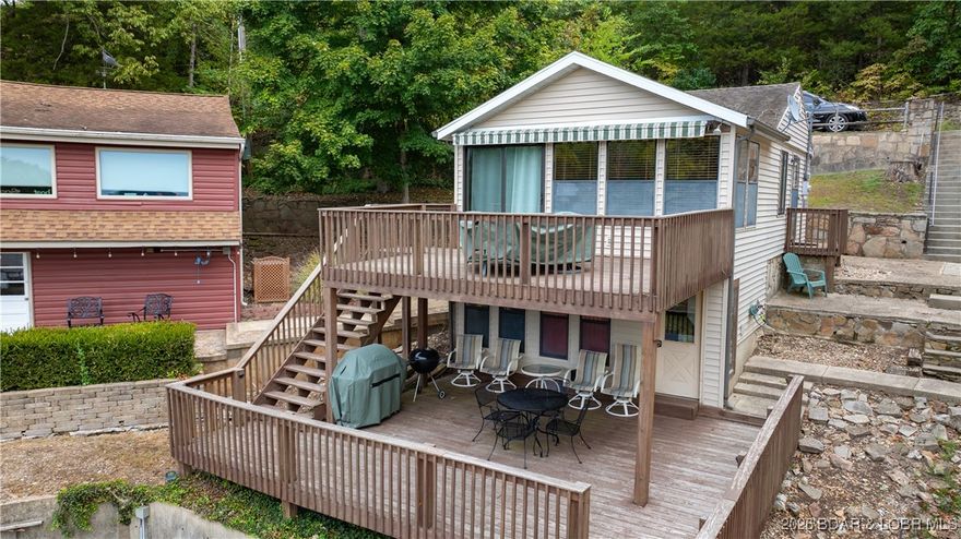 Located in Jackson Hollow Cove on the 3 mile marker of the Little Niangua and just off of historic state highway EE, this one bedroom, one bathroom cabin with its 80' of shoreline and a wonderful two-well dock comes with two decks that offer plenty of room so everyone can enjoy the incredible views and sunsets. This completely turnkey cabin has been kept in pristine condition by the owners and is smartly furnished making the most of the square footage both inside the property and outside. Just a short walk down a very gentle lot and you're at the 2 well dock with a swim platform, a boat hoist and double PWC lift included as well. The lower level boasts plenty of storage for lake toys and/or tools and also houses the stacked washer / dryer and additional refrigerator. Plus, you also have your very own private boat ramp to use. And in the Welcome Subdivision, nightly rentals are not allowed, so this peaceful retreat stays just that: peaceful. Whether you're looking for a charming lakefront getaway or a starter fulltime lakefront home, 591 Welcome Drive is one to check out.