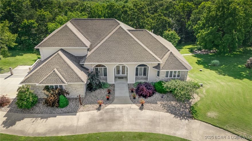 Welcome to Grande Highland Estates! This stunning corner-lot estate sits gracefully on 1.3 acres w/a stately circle drive. Step into a marble tile hall to be greeted by soaring 18-foot ceilings & floor-to-ceiling windows flanking a fireplace that anchors the great room. An elegant, all-white kitchen was designed for everyday living & effortless entertaining featuring a wraparound island,abundant cabinetry, charming breakfast nook w/built-in hutch, & walk-in pantry. An elegant formal dining room & the main office boasts huge arched windows. Retreat to the luxurious main-level primary suite, a sanctuary w/romantic fireplace, his & her spa-like bathrooms, both w/tiled walk-in showers, hers w/jetted sunken tub, both w/vanities, & walk-in closets ideal for personal space & comfort. Upstairs offers 2 spacious bedrooms w/private baths & a loft overlooking the great room. A finished walkout lower level expands the home's potential w/full guest quarters-incl. a 2nd kitchen 2 more bedrooms, generous living & game areas, & its own garage-ideal for extended stays or multi-generational living. Outdoors, mature trees offer privacy & shade. Deck, hot tub, & screen porches invite fun & relaxation.