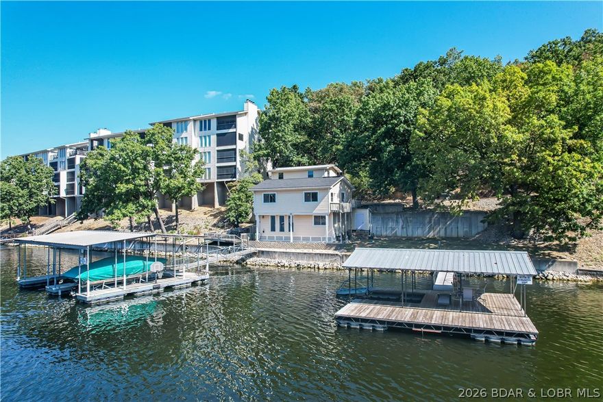 If you are looking for that cove protected lakefront home at a reasonable price, look no further, this is the one!  Perfect spot in a wonderful cove with nearly 120 feet of beautiful shoreline. They even have 2 docks & still have plenty of wonderful swimming space. Home has been loved, cared for & updated with newer flooring, roof, fresh paint etc. The biggest update was a new septic system installed just a few years ago. One of the coolest features of the property is the gentle topography from the house/deck to the lake. The house sits close to the water and there are only a few steps to ground level. The retaining wall is also nice as it holds back the parking area to provide a huge lakefront flat spot. Plenty of parking and even a garage to store your toys. The home is 3 bedrooms and 2 baths but the sellers have very nicely finished the area above the garage adding 2 additional bedrooms and a 3rd bath. This is a great area for family, guests or anyone that loves visiting the lake. Home has done well on vacation rental the last several years and is completely ready if that interests you. Fully stocked with furniture, furnishings, electronics, & everything you need to get started.