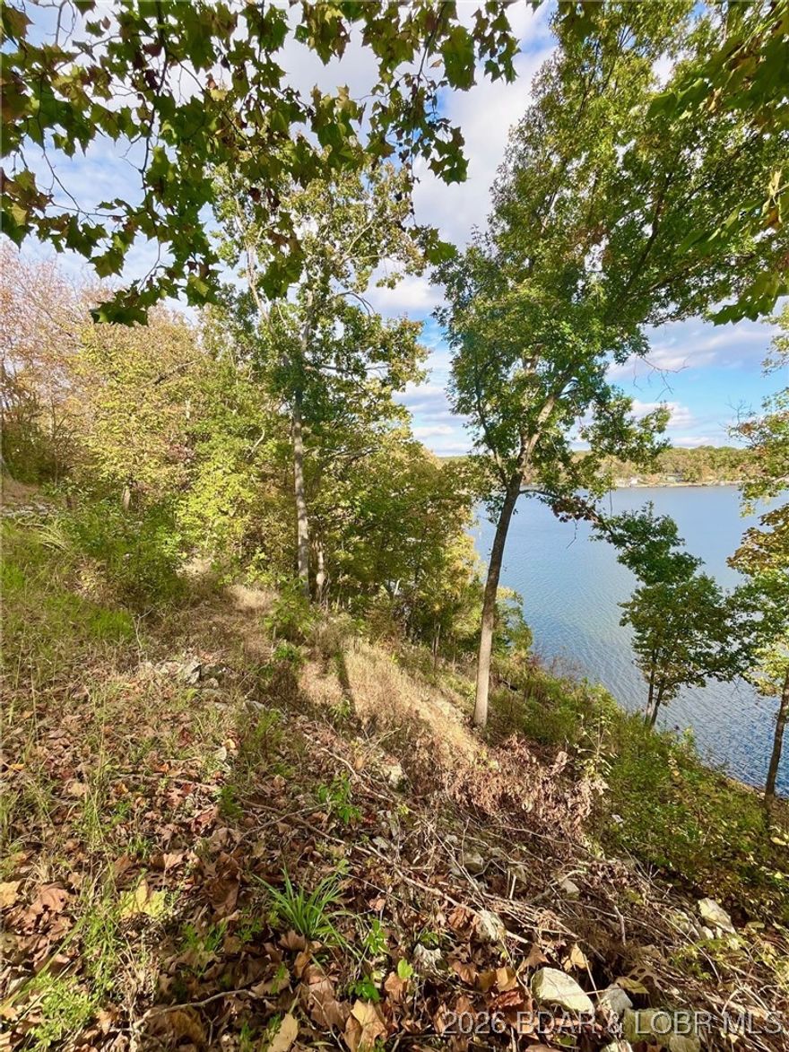 Stunning 100-foot lakefront lot with breathtaking, miles-long views across a wide, scenic Indian Creek cove at Lake of the Ozarks. Cleared and ready for your new home, this lot offers sewer, electric, and high-speed internet availability. Located in a single-family residential development surrounded by well-maintained, attractive homes. Deep, wide cove ideal for swimming, boating, and fishing. Boat dock permissible in accordance with Ameren rules and regulations. Central location within easy driving distance of St. Louis and Kansas City. Motivated sellers—don’t miss this exceptional lakefront opportunity. Adjoining lake Lot #5 of Hidden Treasures MLS# 3550717, available for extra dollars $127,000.