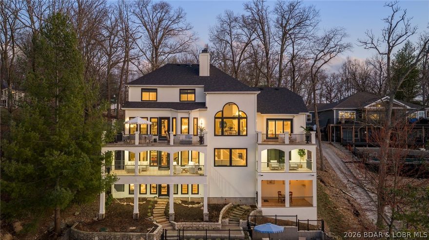 Located at the 13 MM in Porto Cima, MO this remarkable lakefront estate captures sweeping panoramic views from nearly every room. With 7 bedrooms and 5.5 baths, the thoughtfully designed layout features main-level living and private guest accommodations ideal for hosting family and friends. Vaulted ceilings, crown molding, and tray ceilings create an atmosphere of timeless elegance throughout the home. The kitchen showcases granite countertops, abundant space for entertaining, and seamless flow into the main living areas. Retreat to the expansive primary suite, where a spa-like bath with soaking tub and walk-in shower provides the perfect place to unwind. Features include a game room with wet bar and its own sport court! Outdoor living reaches another level with five decks overlooking the lake, a heated saltwater pool, and a lakeside patio with fire pit—all perfect for enjoying the spectacular Four Seasons fireworks display right from home. Boaters will appreciate the two-well private dock with slips measuring 16x52 and 16x48, offering ample space for larger vessels. This is more than a home—it’s Porto Cima lakefront living at its finest.