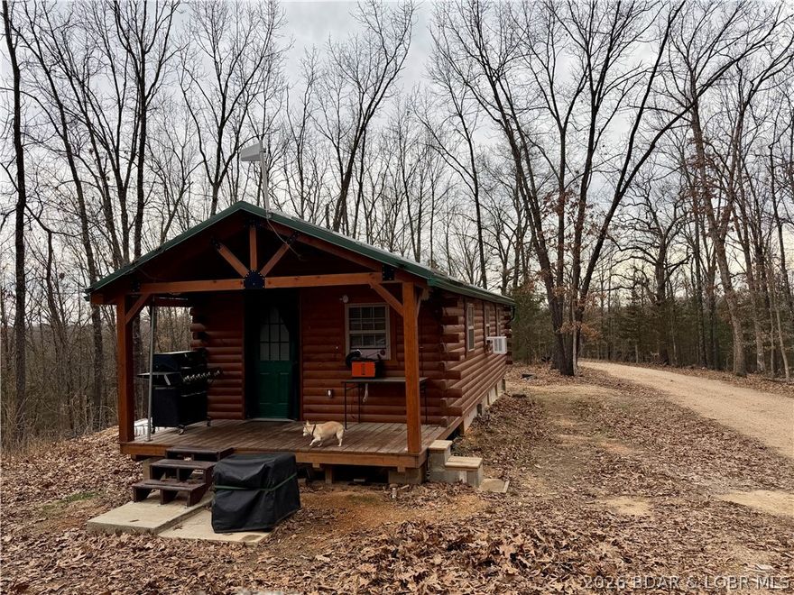 OFF GRID CABIN in the woods. Beautiful log cabin built in 2024 on 5.6 acres of wooded land. 506 sqft with fully functional kitchen including refrigerator, propane stove/oven and sink. Full size bathroom with walk-in shower and on demand hot water. Wood stove is not installed yet but comes with the property. Currently using diesel heater for heat. Solar panels with PV combiner box, batteries 48v invertor with 15kw hrs of storage, 7500 watt, Westinghouse dual fuel generator, rain catchment system with IBC totes that hold 550 gallons of water. Seaflo 55 series Diaphragm Pump for water usage (3 separate sediment filters) under cabin easily accessible through trap door in cabin. Additional framed, heavy vinyl, tent currently set up as a workshop; complete with door, flooring, outdoor shower and porch. Could be reconfigured for a green house. Electric pole nearby on Kolb Hollow Rd. would be easy to jump off of should you choose. Perfect for a hunting cabin or for fisherman enjoying the Lake of the Ozarks. Peaceful setting with town of Climax Springs offering restaurants, hardware store, civic center, library, gas and groceries nearby.