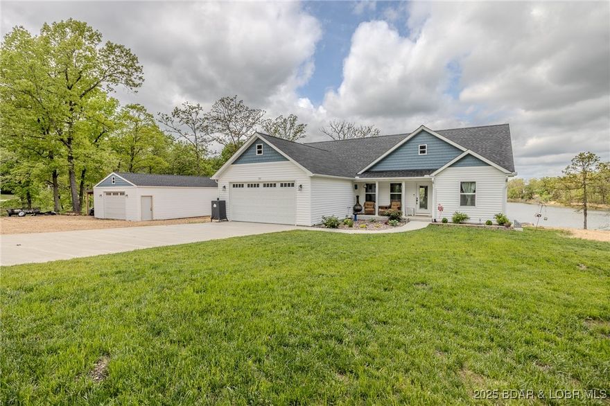 Welcome to 735 Lake of the Woods Dr in Macks Creek—an exceptional 2022-built home offering privacy and lakefront living on 3.14 acres (7 lots) along a private 6.5-acre lake. With only a few homes on the lake, you’ll enjoy a peaceful, secluded setting. This spacious home features approximately 2,960 sqft with 5 bedrooms, 3 full baths, 2 living areas and a 2-car attached garage. The main level offers vaulted ceilings and luxury vinyl plank flooring throughout the living, kitchen, dining, laundry and guest bath areas, along with 3 bedrooms and 2 full baths. The primary suite includes a walk-in closet and private bath with onyx shower and double vanity. The lower level is complete with a second living area featuring an electric stone fireplace, 2 additional bedrooms, a third full bath and a large storage/utility room. Walk out to the fenced backyard and take in beautiful lake views. The standout feature is the 24x40 detached shop which includes dual mini splits, workspace and a 32x12 lean-to. Newer bult home means peace of mind for years to come! This is a great buy!!