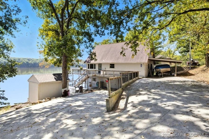 Turnkey lakefront getaway on the 80 MM! This beautiful home checks
every box, from its stunning panoramic views to sleeping 16 guests
comfortably. Perfect for full time living or weekend escape. Key
features: Main level includes a full kitchen, dining area, a living room
with a fire place, and a deck with views of the Osage. Upper level
bonus area with a trundle bed, sitting space, 2 additional bedrooms and
full bathroom. The walkout basement offers more sleeping area for
extended family and friends. Don't forget the 2 car garage and
additional carport ensuring easy access and plenty of parking. Prime
location for jumping in your boat and heading to dinner. This home is ready for you to start making memories.