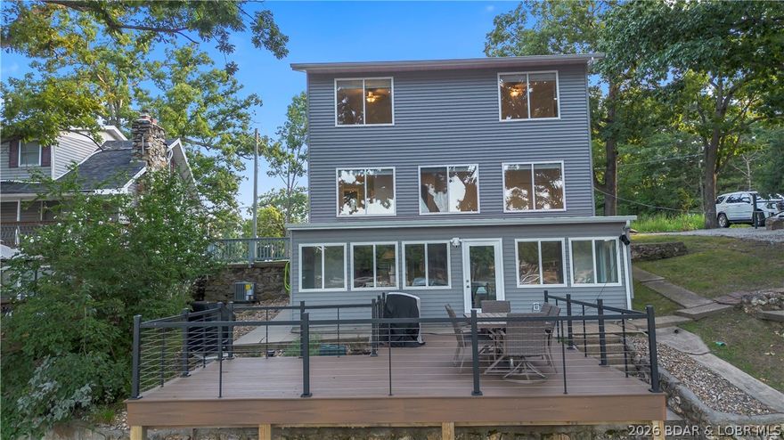 Enjoy the perfect balance of fun and tranquility at the lake! Ideally situated near Lake House 13 and Frankie & Louie’s and only 15 minutes from the Bagnell Dam Strip and Baxter’s Lakeside Grill, this completely remodeled lakefront home offers the best of Lake of the Ozarks living. This 3-bedroom, 2.5-bath retreat sits in a peaceful no-wake cove with beautiful main channel views. The exterior has been fully updated with new composite decking, siding, gutters, fascia, roof, and a brand-new Trico dock featuring a 14x40 slip and oversized swim platform. Inside, the home shines with a fully renovated kitchen offering new cabinetry, solid-surface countertops, and center island, along with new hardwood flooring, carpet, doors, bathroom vanities, and updated HVAC system throughout. A detached garage/boathouse provides endless possibilities—use as additional storage, a bunkhouse for guests, or transform into the ultimate lakeside game and entertaining space. Turn-key, stylish, and perfectly located—this is true Lake of the Ozarks living.