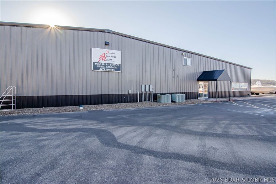 High-visibility commercial opportunity in Sunrise Beach just minutes from Laurie, featuring 512’ of Hwy 5 frontage and exceptional exposure in one of Lake of the Ozarks’ busiest corridors. This expansive 16,000± SF facility (plus mezzanine) serves as the a highway retail and service location and operates in tandem with their waterfront marina less than 5 minutes away. Properties may be purchased together or separately, offering flexibility for investors or owner/operators. The building includes showroom, parts department, multiple offices, & a massive 8-stall service shop with room for expansion. New asphalt parking lot provides ample space for boats, trailers, & customer parking. Known as a major boating supply destination, the store generates strong merchandise and parts sales while servicing boats from both ends of the lake, aided by nearby ramp access at the 8MM.  Designed for efficiency and scale, this location allows full-service operations under one roof with outstanding highway presence and steady traffic. Acquire a proven, high-volume commercial asset in the heart of Missouri’s premier recreational market!  Building is in great shape and could easily be repurposed.