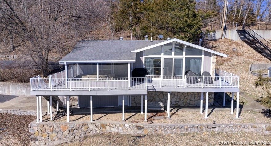 Looking for a lakefront home you can add your personal touch and updates to?  This lakefront home in Lick Branch Cove at the 
5 MM offers a cove location with a main channel views-plus an additional lot is included.  This 3 bedroom, 2 bath property sits on 1.47 acres with approximately 100 feet of lake frontage and a private 3-well dock with wood decking.   1,147 sq ft home offers a gently sloped lot and peaceful cove setting and immaculate views. It has a partial basement and tuck under garage for all your storage needs. Outdoor spaces include a covered porch, screened porch, open deck, and easy access to navigable water.  Suitable for full-time living, a weekend lake home, or investment flipper. This home includes the dock, boat & waverunner lifts, outdoor furniture and interior furniture. Plenty of parking and even more with the extra lot with plenty of room for expansion.