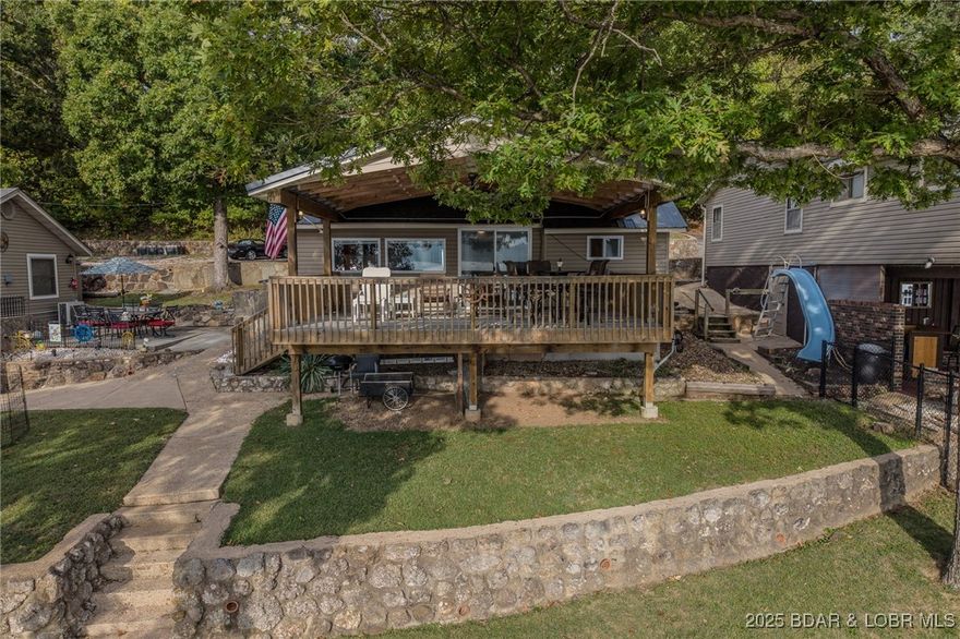 If you are searching for a Lakefront property with great fishing, great neighbors, deep water and a panoramic view you won't believe, then this is the one.  Also the level lot is a very big plus!  The 345 sq ft covered deck can also be walled in for additional living space. The Property comes with (3) slips in the dock.  Also there is a fenced in area for boat trailers!  Call today for your personal tour of this extremely nice lakefront property!