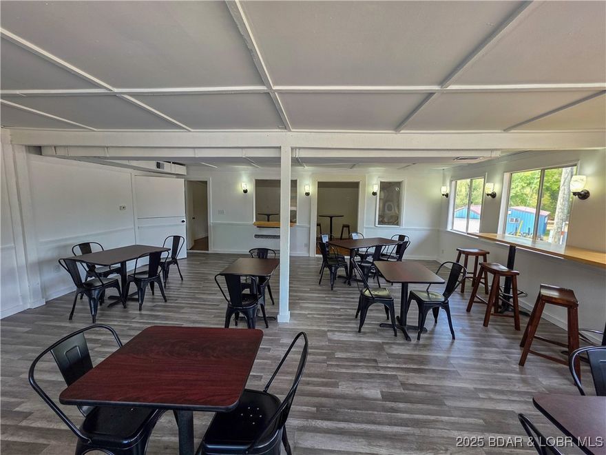 Prime opportunity in a charming small-town setting with an exceptional location!  This commercial property is ready to bring your business vision to life and is perfectly suited for a restaurant. It comes furnished with many extras like 2 prep station coolers, 2 double fryers, electric flat top stove, tables, chairs, benches & more, making it easy to get started right away. This property is right along a high traffic highway that neighbors a campground, gas station & very close to motels & the Gravois Mills Public Access to the beautiful Lake of the Ozarks.  What a perfect location for your business! Recent updates include new lighting, fresh paint, updated flooring, and a durable new metal roof—giving the space a clean, modern, and welcoming feel. With its inviting location in the heart of a friendly town, this property offers great potential for a thriving restaurant, café, or other business venture. Let's take a look!