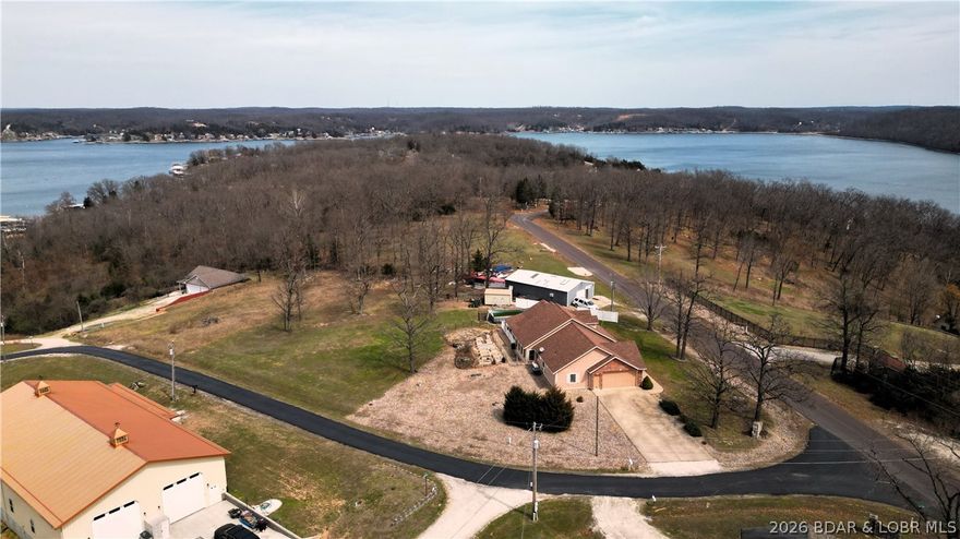 Nestled on a picturesque 1-acre lot, this beautiful brick home offers the rare luxury of stunning lake views on both sides—sunrise coffee, sunset serenity. A nearby boat ramp just down the hill makes lake days effortless, whether you're chasing early morning fishing or evening cruises. The property is primed for both relaxation and self-sufficiency with homesteaders in mind, featuring established raised garden beds ready for your summer harvest, a chicken house for fresh eggs, and an above-ground pool perfect for cooling off on warm Missouri days. The attached workshop is equipped with mini split for heating and cooling when needed.   With ample space to build a shop, expand, or simply enjoy the open surroundings, this property blends peaceful country living with everyday convenience and all in a fabulous location. Whether you're looking for a full-time residence or a weekend escape, this one delivers the kind of Lifestyle people dream about.