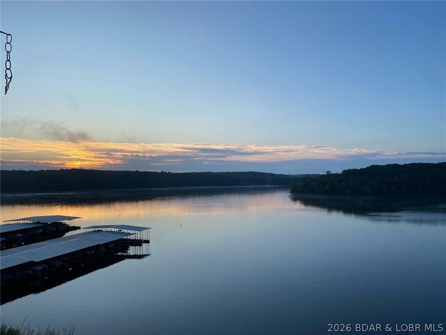 Experience the ultimate lake lifestyle in this stunning 3-br, 2-bath condo at the 5MM of the Grand Glaize Arm at Lake of the Ozarks. Nestled within the State Park, this condo offers an unparalleled blend of tranquility & adventure. Enjoy a updated interior featuring a nautical flair. Step out to morning sunrises & one of the best unobstructed panoramic views in the complex that can be enjoyed from the deck, living room & master br. Being an end unit, extra windows flood the space with natural light, highlighting extensive 2023 renovations-new kitchen & bathroom cabinets/counters, fresh flooring, updated paint, & new hot water heater. 12x30 boat slip included, giving you immediate access to the best boating, fishing, & water sport areas. Only a short boat ride away are iconic spots like Dog Days, Backwater Jacks, Shorty Pants, & Redhead. The complex boasts a community pool, clubhouse w/workout room & convenient on-site trailer parking. The complex is nestled in the State Park where a beach, hiking/biking trails, boat launch & horseback riding are enjoyed. Best of all, you are only 10 miles/15 min from shopping & dining, avoiding traffic hassles. Dreams to Reality!  Call Today!