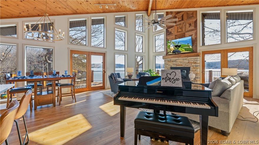 WOW factor from the moment you walk in—this spectacular furnished lakefront home showcases dramatic walls of glass and unforgettable lake views! Designed for true main-level living, this architectural beauty offers an open floor plan with seamless indoor-outdoor flow. The great room features vaulted ceilings, LVP flooring, electric fireplace plus floor-to-ceiling windows capturing lake views & fill the home with natural light. Chef's kitchen offers quartz countertops, stylish backsplash & newer appliances—perfect for entertaining. Step outside to the expansive lakeside decks, ideal for relaxing on lake time. The lakeside primary suite includes an updated bath with walk-in shower. A guest bedroom, full bath, and laundry complete the main level. The lower level welcomes you with a spacious family room & wet bar, two guest bedrooms, full bath, and bonus storage. Improvments include flooring, Andersen windows in lower, new roof, freshly painted exterior, stained decks, lighting and fixtures, custom lakeside fire pit, engineered septic system, retaining wall for additional parking. Deep water, cove with main channel views! Meticulously maintained and move-in-ready!