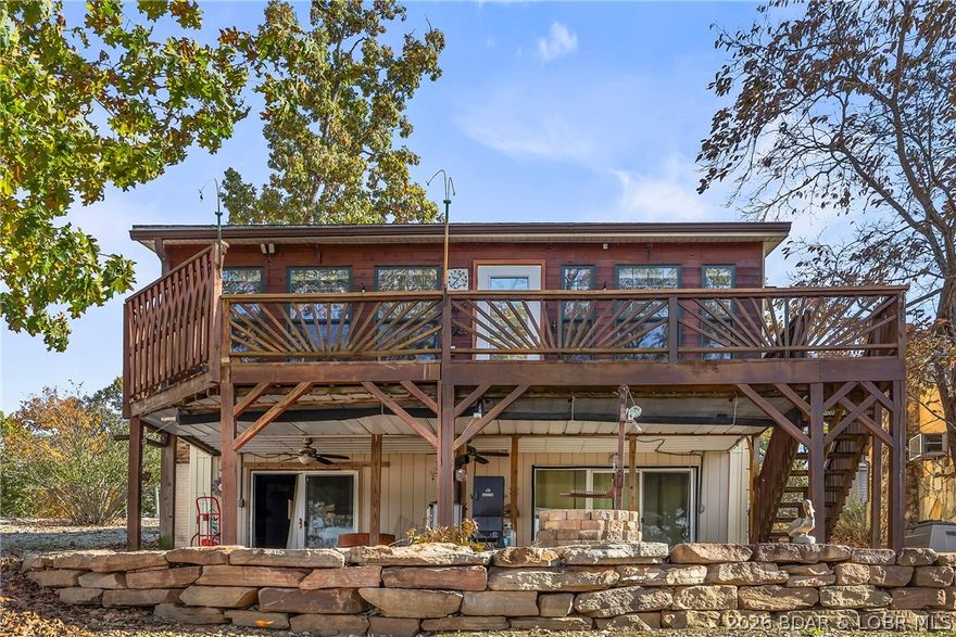 Motivated Sellers - This lakefront cabin has grown over the years into a comfortable home with a terrific 3-car garage/workshop every guy will want. Current owners have up-dated the large eat-in kitchen with LVP flooring and custom Rustic Hickory cabinets. They brought wood paneling from an old schoolhouse in Iowa for the staircase. They converted the original boat garage into en-suite master suite with brick flooring and access to the lakeside patio and the laundry/storage area. The detached garage has an office/workshop/craft area with a window heat pump unit. Under the wrap around deck of the garage is additional storage for your golf cart, riding lawn mower, etc. Great location by water or road, close to restaurants, shopping, and marinas. If you're wanting that "Lakey" vibe - This is your new lake home.