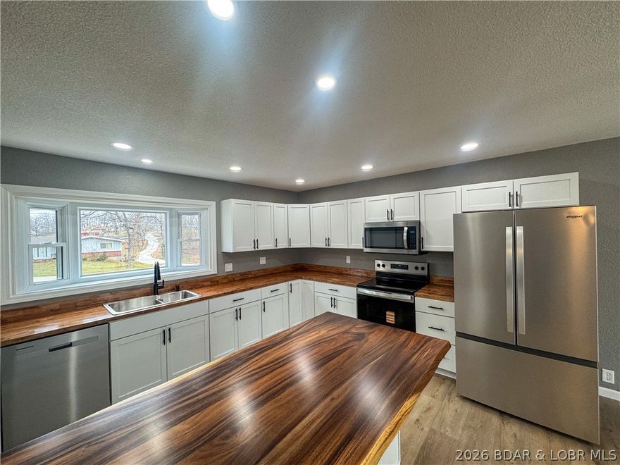 BEAUTIFUL!  Completely remodeled & move-in ready, this 3 bed, 2 full bath home offers the perfect blend of style, comfort, and space. Situated on two parcels, you’ll enjoy an oversized yard with plenty of room to relax or entertain. Step inside to find all-new flooring, updated lighting, and a fresh, modern feel throughout. The stunning kitchen is truly a showstopper, featuring brand-new Whirlpool appliances, eye-catching countertops, and a layout designed for both function and style. Both bathrooms have been beautifully updated with walk-in showers, offering a clean, modern look & everyday convenience. The lower level  adds even more versatility with a bonus room—perfect for a home office, game room, or guest space—along with a nice-sized utility/laundry area that provides excellent storage or could double as a workshop plus a bedroom and bathroom all found in the walk-out basement. Enjoy your morning coffee on the welcoming front porch or unwind on the large back deck just off the sliding glass door—ideal for taking in the peaceful backyard views. With all the updates already done, this home is ready for its next owner to simply move in and enjoy!