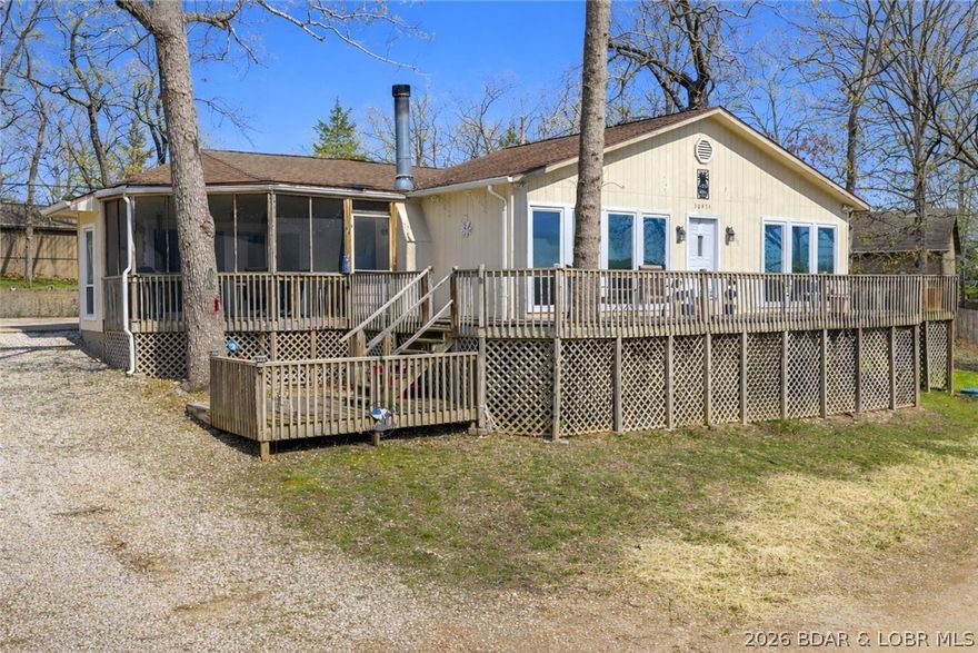 Wake up to beautiful lake views in this main level living home, situated in a peaceful neighborhood. This 3bed/2bath home includes a new HVAC that was just installed AND recently just hooked up to city sewer! Exterior features include multiple deck spaces (open & covered), an ideal screened-in deck, gentle topography, abundant parking & sits on 2 lots. Oversized 2-car garage is a heated & cooled pull-through—super convenient! Inside offers a spacious living room with LVP flooring & gas fireplace, large kitchen with ample cabinet/counter space, unique ceiling detail above the island, pantry & a light-filled sunroom for seamless indoor/outdoor living. Primary suite includes lake views, deck access, walk-in closet, walk-in shower & soaking tub. Energy efficient with heat pump & attic fan—avg electric under $100! Large crawlspace for easy access & storage. Boat ramp just a short walk away; located at the 1.5MM of the Gravois by water. Seller is offering a $5,000 concession on exterior painting upon acceptable offer!