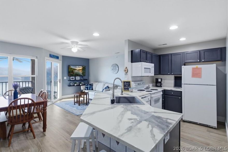 This 1-Bed, 1-Bath, condo spans 589 Sq Ft and is perfectly situated in the scenic State Park at the 5 Mile-Marker of the Grand Glaize Arm - and best of all, ZERO STEPS! This Walk-In unit comes TURN-KEY and features many updates such as new LVP flooring, Epoxy Countertops, Newer Appliances and a functional open layout designed for easy lake living. Relax on the screened-in porch and enjoy the peaceful setting after a day on the water! Enjoy a front row seat to Lake of the Ozarks' BIGGEST event - The Shootout, which draws THOUSANDS of guest every year! A 12x32 boat slip is included and NIGHTLY RENTALS are allowed making this unit perfect for a weekend retreat, investment property or full-time living! The complex offers top notch amenities such as an Outdoor Pool, Playground for the Kids, Clubhouse, Fitness Center, Outdoor Grill Area and Fire Pit Area. The Grand Glaize arm is great for tubing, skiing, floating and hanging out with friends/family for a fun filled day on the water. You're just minutes by boat to popular destinations such as Party Cove, Dog Days, Backwater Jacks, Redhead and the Oasis Amusement Park which is set to open in the Fall of 2026! Don't miss this opportunity!