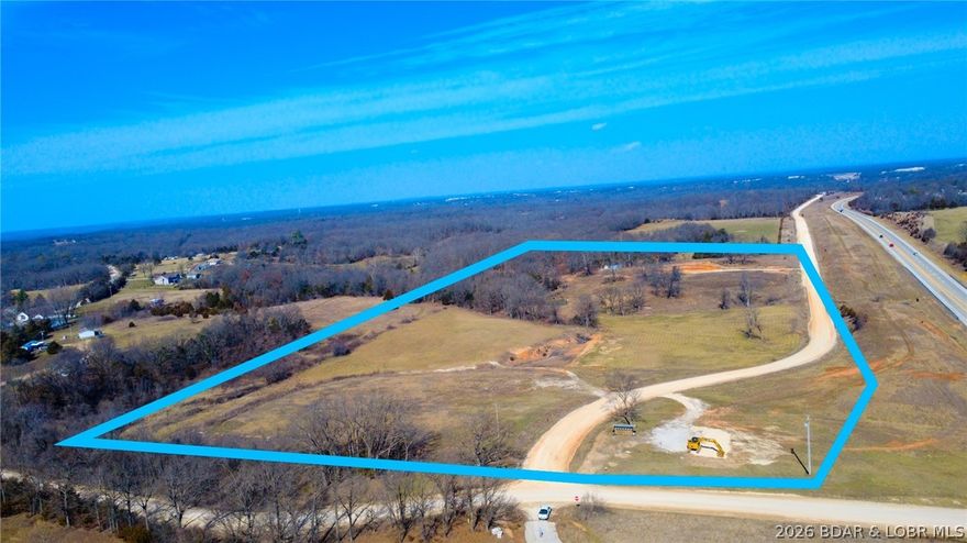 Developers and investors — take notice. This 20.57-acre tract just 3 minutes south of Camdenton along State Hwy 5 at Dry Hollow Rd is strategically positioned for commercial or residential type development. With Agricultural zoning and located outside city limits, the property offers flexibility for a wide range of uses beyond the norm. The level terrain supports efficient site development, and highway frontage provides excellent visibility and access for operations such as a UPS distribution hub, shop rental complexes, contractor yards, equipment dealerships, concrete or asphalt facilities, AI Data Center, or other ventures like a residential neighborhood. 
Public water is located across Dry Hollow Rd and electric is accessible nearby, helping streamline utility planning. A pond on the property adds functional water access and site character. With no HOA restrictions and strong regional connectivity on the State Hwy 54 and State Hwy 5 corridor, this parcel presents a rare opportunity for scalable development in a strong growth corridor with high traffic exposure. Seller would consider selling 4 acres on north end separately. Call or text for more information!