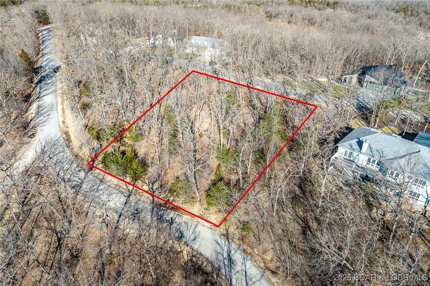 Enjoy the charm of ever-changing lake scenery with this Seasonal View lot at The Villages at Shawnee Bend. Partial lake views emerge throughout the year, offering a unique connection to the surrounding landscape while maintaining privacy and natural beauty. The community sets itself apart with a grand waterfall entrance and an impressive lineup of amenities, including a clubhouse, resort-style pool, championship tennis courts, and pickleball facilities. Parks, and playgrounds enhance the lake lifestyle, while paved streets and underground utilities provide modern convenience. This lot is ideal for a full-time residence or a relaxing weekend escape.
