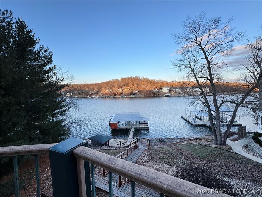 A resort-inspired custom-built lakefront retreat w/ spectacular views on 8mm, offering upscale design & proven short-term rental (over $100k per yr). Fully furnished - just bring friends, family & suitcases - let the vacation begin! This open-concept sleeps 20 & showcases vaulted ceilings in a grand hearth room, highlighted by dramatic windows framing the water. A well-appointed kitchen features stainless steel appliances, custom cabinetry, granite countertops & breakfast bar + additional dining area to feed a crowd. 6 spacious bedrooms include 2 lakeside,private king suites w/ spa-style full baths, & a playful 10-person bunkroom. Outside, enjoy a thoughtfully-designed lakeside shower house, spacious screened-in patio, firepit, barbecue grills, & fully functional tiki bar w/ water & electric. Situated in a wide, deep-water cove perfect for swimming, fishing & water sports, the property also includes a two-slip dock w/ tri-toon lift, 2 PWC platform & swim deck. Ideally located by land & water just minutes from dining, entertainment, & local attractions, this exceptional home delivers luxury craftsmanship, lifestyle, & strong rental history in one remarkable property @ $1000/day.