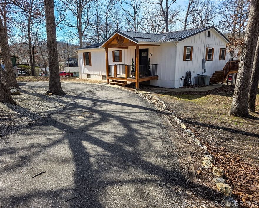 Newly remodeled & move-in ready, this chic lake home offers the kind of lifestyle buyers dream about. The open main level features a spacious living room, kitchen & dining area with quartz countertops throughout, a huge island with storage, walk in pantry behind a sliding barn door. There are multiple built in cabinet/storage areas in entry & around both fireplace sections. Walk out to either deck area from the living room & enjoy the outdoors. The oversized primary suite is a true retreat with sitting area, electric fireplace, deck access, office, big walk in closet & bath with double sinks & walk-in shower. The main level also includes laundry, half bath & a storage room with large built-in safe. The lower-level walkout includes a second kitchen, dining area, family room, 2 bedrooms, full bath & utility room—ideal for guests-mother-in-law quarters & VRBO potential. About an acre with room to spread out, quick path to dock has a concrete slab with electric for gazebo/firepit, 2-slip dock has new decking, a swim platform, lift & good water. Paved circle drive & on the lake side there's a carport area, patio & heated detached shop/garage for all your hobbies & toys.