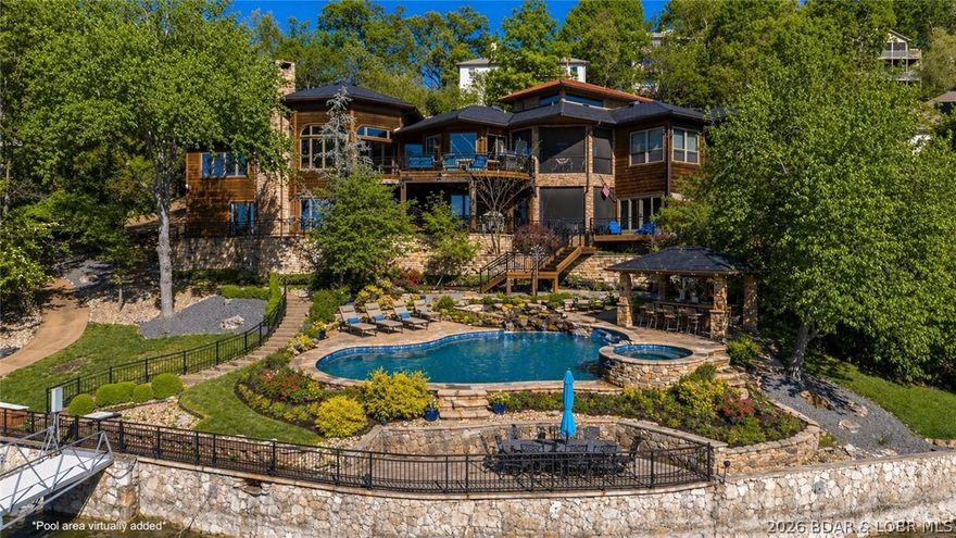 Lodge-style lakefront retreat sitting on over 1 acre with an impressive 276 feet of lakefront. Situated in Four Seasons, this 6 bedroom home features 7 bathrooms with every bedroom designed as a private ensuite. The cove location is the perfect blend of water while still capturing wide-open views, with plenty of room to add a pool if desired. Originally built in 1993 and completely renovated down to the studs in 2009, the home showcases hand-scraped hickory floors, a new DaVinci slate tile roof, and quality finishes throughout. Multiple expansive decks create several entertaining spaces, complemented by a dedicated hot tub room overlooking the lake. Inside also includes an office and private theatre room for added functionality, while the home comes fully furnished, so you can move right in and start enjoying the lake. The large dock features new concrete tiles along with a 15x48 slip, 12x36 slip, and dual PWC slips to accommodate all your lake needs. A 3-car garage and ample additional parking complete the package. This is a rare opportunity to own a true lakefront estate with acreage, extensive lakefrontage, and exceptional amenities.