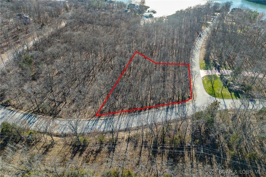 Surrounded by mature trees and natural Ozarks beauty, this wooded lot at The Villages at Shawnee Bend offers a peaceful, private setting within one of Lake of the Ozarks’ most distinguished communities. From the moment you arrive through the grand waterfall entrance, the neighborhood’s upscale character is clear. Residents enjoy access to a beautifully appointed clubhouse, resort-style community pool, championship tennis courts, and pickleball facilities, along with parks, and playgrounds. Paved roads and underground utilities make building seamless while preserving the natural landscape. Ideal for a custom home or lake retreat, this wooded homesite blends serenity, luxury, and an active lake lifestyle.