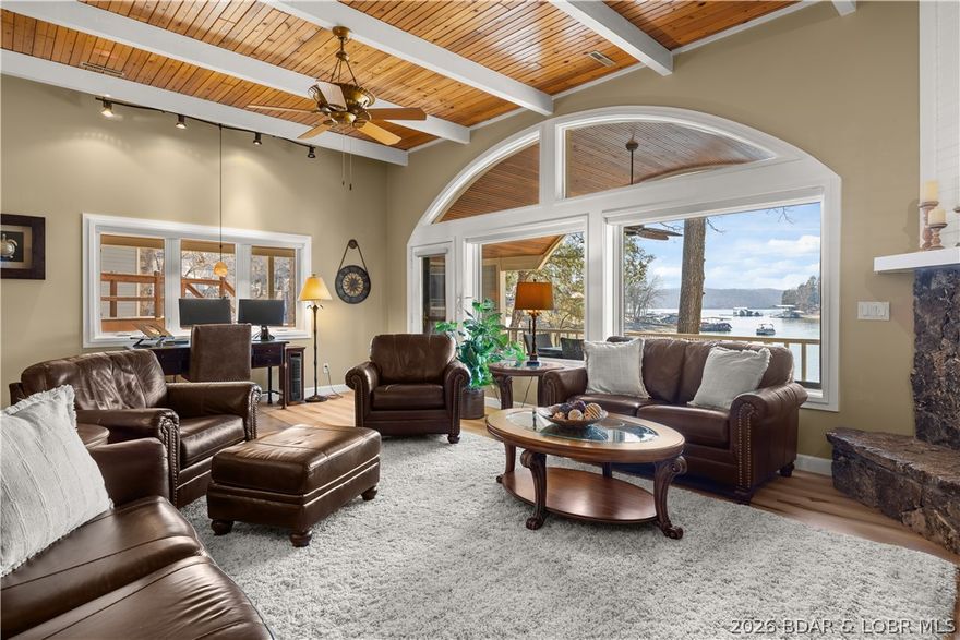 Experience tranquil lakeside living in this luxurious 3BR/3BA villa at the 25MM. Nestled in a protected NO-WAKE cove, this residence is part of the exclusive Lake Point community—a gated, 20-unit non-rental enclave surrounded by 30 acres of wooded privacy. Boasting top-quality finishes from a 2025 remodel, the home features engineered hardwood, updated staircases, and LVP. The spacious living room shines with tongue-and-groove beamed ceilings, a stone fireplace, and new Andersen lakeside windows with plantation shutters. The gourmet kitchen highlights sleek granite countertops, KitchenAid appliances, and a wet bar with a commercial-grade icemaker. Retreat to the upper-level primary suite with heated bathroom floors. This unit includes a large covered deck, attic fan, and extra storage. Boaters will love the two massive slips (expandable to 14x54 and 18x54) plus a double PWC lift. Enjoy resort amenities like a pool, tennis, and pickleball courts, all while being minutes from dining and shopping. This is a rare, low-traffic sanctuary where every detail has been perfected. Experience the best of lake life in a one-of-a-kind setting! This turnkey masterpiece is ready for its new owner!