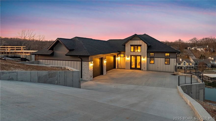 Recently completed by Thomas Construction, this luxury residence presents a turnkey opportunity within the Harpers Cov lake community. Blending modern design with timeless architecture, the 4-bed, 5-bath home features oversized windows, elevated ceiling heights, and cantilevered decks positioned for wide cove views.The main level is designed for single-level living and entertaining. A large open kitchen anchors the home and flows directly into the primary living and dining areas, all facing the lake. The main level primary suite includes laundry in the walk-in closet.The lower level offers three en-suite bedrooms, a secondary guest laundry, built-in bar, and an expansive living room suited for gatherings or extended stays. A gently sloped driveway leads to a 4+ car parking area and an oversized 3-car garage. Golf cart paths provide convenient access to the shoreline, docks, and community pool. Ideally located at the 19MM near local marinas, restaurants and shopping. City water/sewer, streetlights, community trash service, and centralized mailboxes add convenience. Boat slips of various sizes are available, and furnishings can be included to create a complete turn-key package.