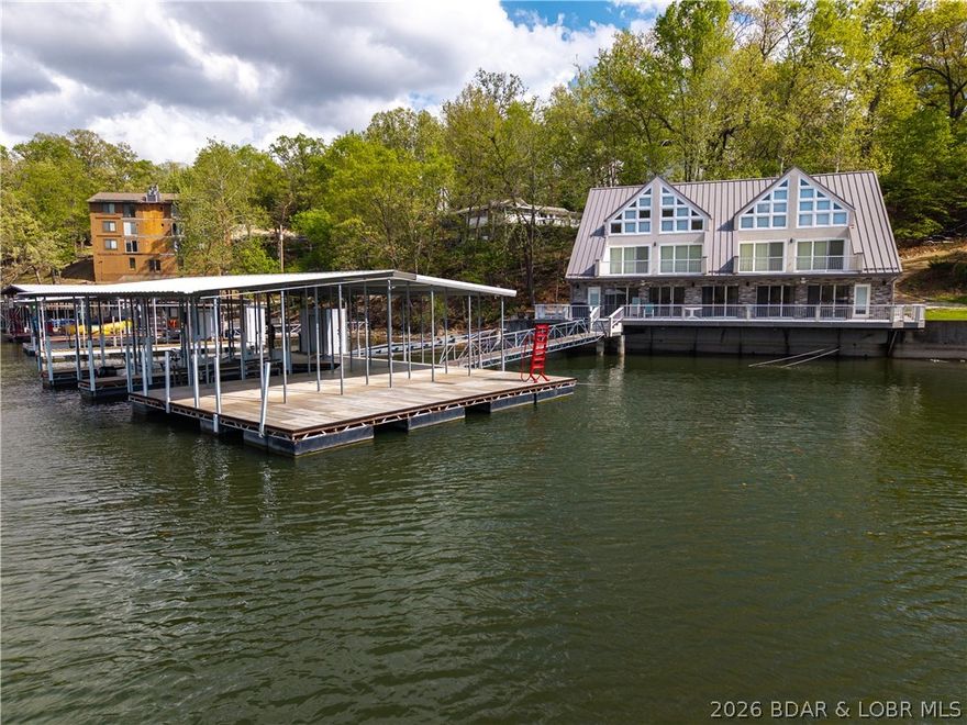 Perched right at the water’s edge—literally as close as you can get—this lakefront retreat delivers the lifestyle buyers come to the Lake for! Newly remodeled, this 6-bedroom, 5.5 bath home offers 3 levels of living space designed for both entertaining & relaxation, all wrapped in panoramic lakeside setting. This deep water, no wake cove gives you the perfect balance of big views, calmer water, while outdoor space maximizes guest's enjoyment. The private dock with swim platform is summer ready with 2 wells (12x32 & 12x28), hoist & potential to convert to 3rd slip. A unique & rare layout with excellent flexibility for multi-family use, featuring a shared wall design with separate bedroom wings & dual staircases leading to private upper-level master suites. This setup is ideal for 2 families to comfortably share the home while maintaining their own privacy. Turnkey & rental friendly this property comes furnished as shown- whether you're looking for a high-demand vacation rental or a personal escape, this open main floor makes hosting large groups effortless. Near Bridgeview Marina 24hr gas dock, Dog Days & the new Oasis, this location delivers the best of Osage Beach entertainment!