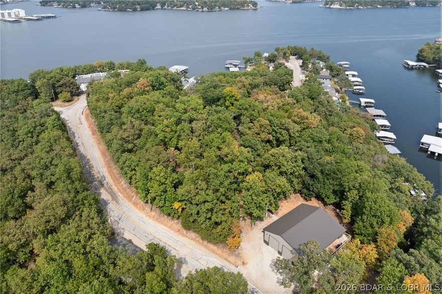Rare opportunity to own a 50x50 quality-built 2022 Shouse while building your Dream Home on the hill in the Heart of Lake Ozark w/ NO HOA, just off MM 3! Nestled on 3.1 wooded acres with 2 acres having year round Lake Views. This partially furnished 2-bed/ 2-bath property perfectly blends privacy with convenience—minutes from shopping, dining, & entertainment. Offering 1,280 sq. ft. of beautifully finished living space & 1,220 sq. ft. of heated shop space, there's plenty of room for RVs, boats, vehicles, or even a home-based business. Interior highlights include an open floor plan, custom cabinetry, granite countertops, stainless steel appliances, LVP flooring, & R-30 insulation for year-round comfort. Enjoy the outdoors with a 75 sq. ft. open deck & a 330 sq. ft. screened-in deck overlooking the peaceful woods. The heated shop is a dream—featuring two 14' garage doors, two 50-amp RV hookups (inside & outside), an RV dump station, & a water softener. This versatile property combines modern living with endless storage, workspace possibilities & Potential Rental Income. A true one-of-a-kind find at Lake of the Ozarks—don't miss your chance to make it yours!