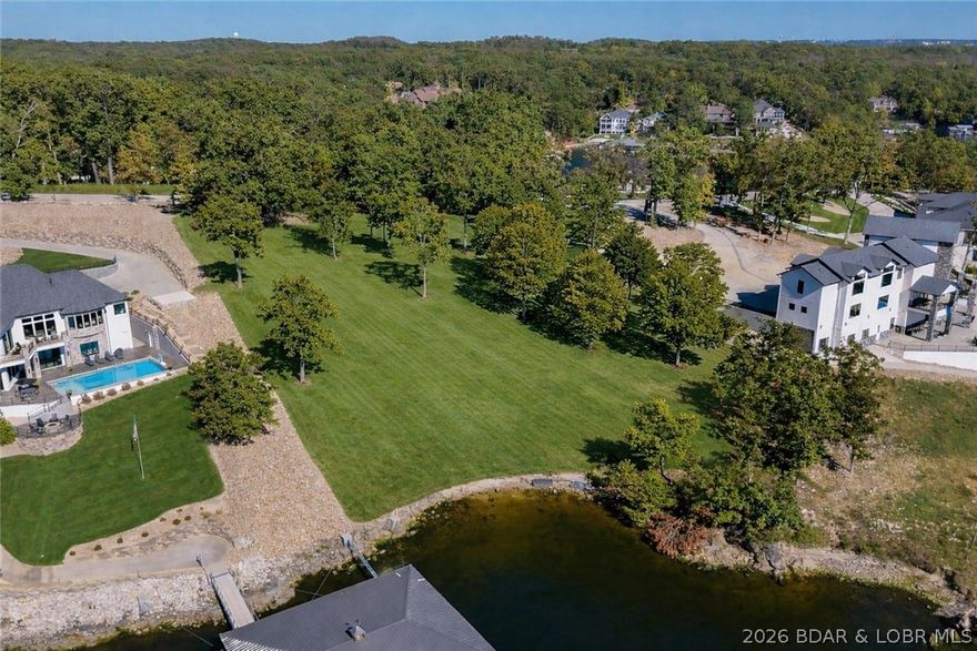 A rare opportunity to create a private lakefront compound within one of the most prestigious gated communities at Lake of the Ozarks. This 1-acre parcel offers an impressive 191 feet of pristine shoreline, delivering expanded privacy, shoreline control, and sweeping main-channel views alongside the adjoining luxury estate (MLS#3584233). Gently sloping terrain and mature hardwoods provide an exceptional canvas for a guest residence, architecturally significant retreat, or custom expansion. Utilities are available, and the generous footprint allows for additional outdoor living, pool design, or private dock configuration. When combined with the neighboring 5,200 sq ft estate, the result is a legacy-level waterfront holding rarely assembled in this caliber of community. Opportunities to control this degree of acreage and shoreline are exceptionally limited. *First right of refusal granted to Buyer of 81 Forest Trace* Once separated, this level of lakefront cannot be reassembled. A strategic acquisition for those who value privacy, scale, and irreplaceable waterfront. An extraordinary offering for those who recognize the value of blue-chip lakefront.
