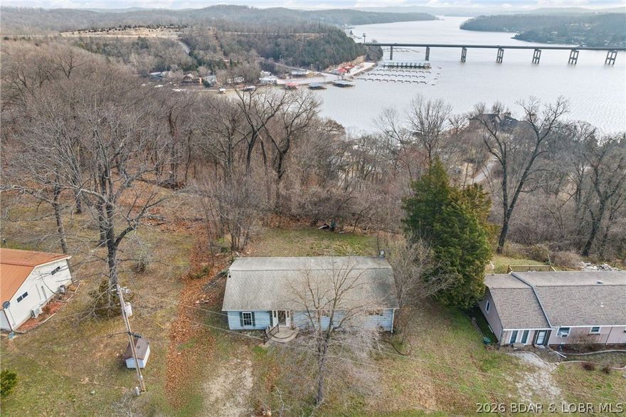 Investor/First-Time Buyer Special! Stunning Seasonal Lake View! 2 Bedroom Home + Huge Bonus Room – Whether you are looking for a weekend getaway to customize, a savvy investment project, or an affordable first home, this property and location are well suited for a variety of options. You are right near The Ozarks Amphitheater, Bridal Cave and Mariners Pier 31. The home is all one level and features a functional 2-bedroom layout with a cozy, inviting feel. The true gem is the very large, private 3rd non-conforming bedroom/bonus room—perfect for an massive master suite, a game room, or a bunk room for guests. Selling AS IS. With a little clearing lakeview could be year-round.
