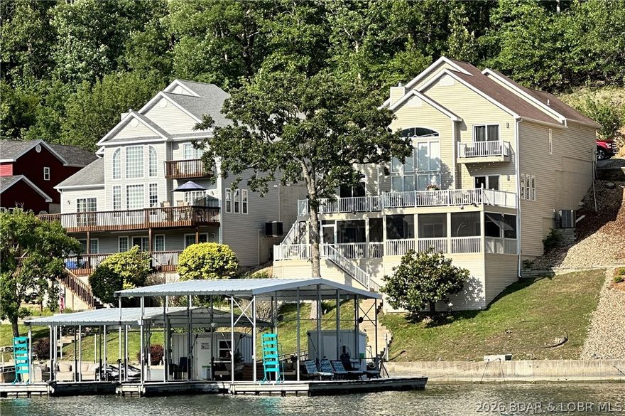 Remodeled to perfection, this exceptional waterfront home features a dramatic wall of windows showcasing breathtaking lake views. A sophisticated neutral palette with custom accents flows throughout, complemented by two private master suites and multiple living areas. Enjoy outdoor living on expansive multi-level decks, including a screened-in area and a beautifully updated space with Trex decking, aluminum railings, and cantina lighting. The hot tub is set in its own separate area, creating a relaxing retreat away from the main entertaining space. Ideally situated in a cove, the property offers calmer waters—perfect for swimming, floating, and enjoying the lake lifestyle. Extensive upgrades include quartz kitchen countertops with waterfall edge, updated furnishings, window treatments, quartz vanity tops, custom tile and glass showers, new flooring, paint, lighting, plumbing fixtures, and more. Additional highlights include expanded parking on a second-tier lot with room for a garage, and a central location by land and water. It appears the existing boat slips may be expanded to accommodate up to 40-foot slips. Pontoon boat and PWCs available for additional purchase.